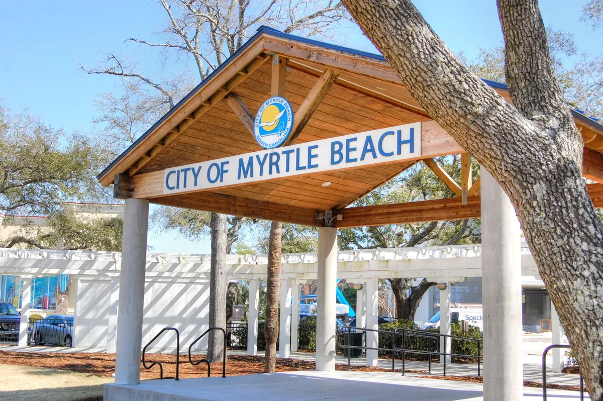 This image features the 'CITY OF MYRTLE BEACH' sign with a wooden structure and trees, representing the broader local community. It hints at the variety of community events, local markets, and seasonal happenings available to winter guests.