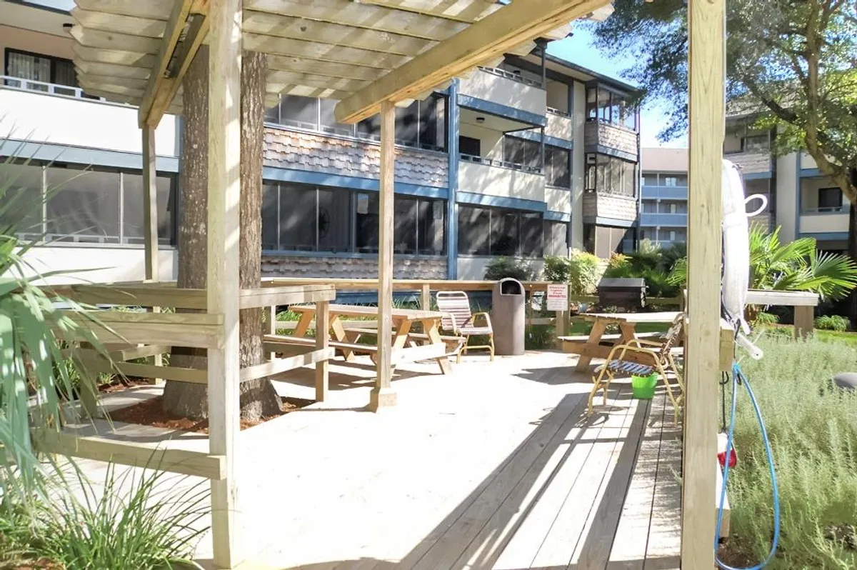 An inviting outdoor area with a pergola, comfortable seating, and lush greenery. This space is set up for group relaxation or a barbecue, with a casual, friendly vibe ideal for gathering with family or friends.